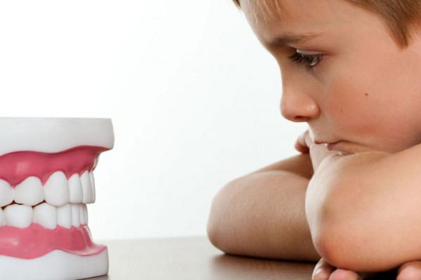 child focusing on teeth mould