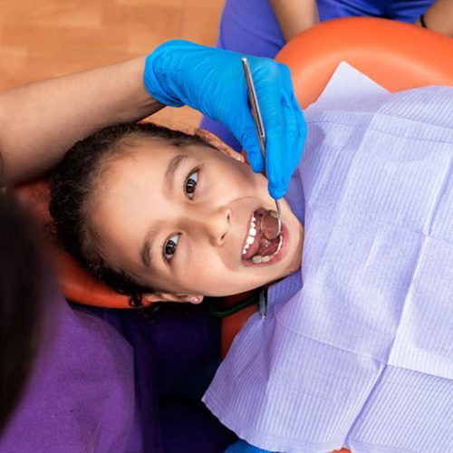 smiling kid having teeth examined